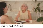 Elderly woman meeting financial advisor for investment at home. Стоковое видео, видеограф Яков Филимонов / Фотобанк Лори