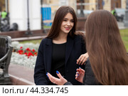 Two cute girlfriends talking while sitting on a park bench. Стоковое фото, фотограф Андрей Аркуша / Фотобанк Лори