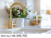 Kitchen sink. Modern new gold faucet, marble countertop. Stylish white sink, Brass faucets in light interior. Golden tap. Domestic Appliances. Gray clean bright household equipment. Contemporary style. Стоковое AI-изображение, AI-художник Марина Демидюк / Фотобанк Лори