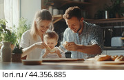 A joyful family prepares food together in a cozy kitchen during a sunny afternoon, sharing laughter and creating memories. Стоковое AI-изображение, AI-художник Сергей Толмачёв / Фотобанк Лори