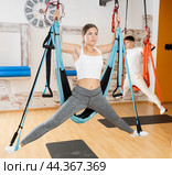 Girl doing side split in suspended hammock during antigravity pilates training. Стоковое фото, фотограф Яков Филимонов / Фотобанк Лори