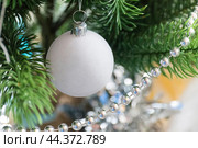 Крупным планом шар и гирлянда на ветке новогодней ёлки. Размытый фон.  Christmas tree background. Стоковое фото, фотограф Лариса Гордеева / Фотобанк Лори
