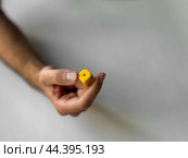 Close-up of hand holding a yellow dice for gaming and luck concepts. Стоковое фото, фотограф Lamina Akulova / Фотобанк Лори