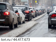 Traffic jam in city on slushy winter evening. Стоковое AI-изображение, AI-художник Владимир Григорьев / Фотобанк Лори
