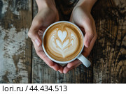 Warm hands holding a latte with artful foam. Стоковое AI-изображение, AI-художник Иван Рябоконь / Фотобанк Лори