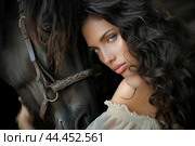 Portrait of a woman with dark, curly hair, posing intimately with a horse. Стоковое AI-изображение, AI-художник Иван Рябоконь / Фотобанк Лори