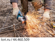 Metal cutting with a hand held machine with a cutting disc. Стоковое фото, фотограф Дмитрий Кобзев / Фотобанк Лори
