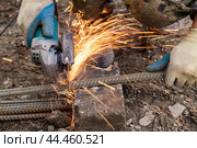 Metal cutting with a hand held machine with a cutting disc. Стоковое фото, фотограф Дмитрий Кобзев / Фотобанк Лори