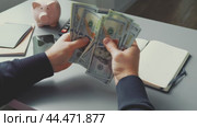 Counting cash and managing finances at a desk with notebook and calculator in view. Стоковое видео, видеограф Сергей Толмачёв / Фотобанк Лори