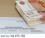 Пачка денег и бланк налоговой декларации 3-НДФЛ. Стоковое фото, фотограф Татьяна Т / Фотобанк Лори