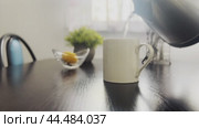Tea is brewed in a white mug on the kitchen table in the early morning. Стоковое видео, видеограф Ярославский Максим / Фотобанк Лори