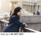 Portrait close-up of beautiful intelligent brunette who walks down street of St. Petersburg in city center. Charming thoughtful woman with long dark hair wanders alone, immersed in thoughts. Стоковое фото, фотограф Natalia Gdovskaia / Фотобанк Лори