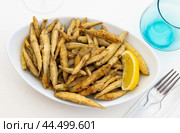 Dish with fried sardines, pilchards or anchovies in batter for traditional Spanish meal. Стоковое фото, фотограф Яков Филимонов / Фотобанк Лори