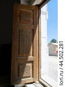 An ancient carved wooden door is open to the courtyard at the Rukhabad Mausoleum in Samarkand, Uzbekistan (2024 год). Стоковое фото, фотограф Сергей Фролов / Фотобанк Лори