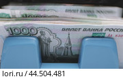 A close-up of a 1000 ruble banknote in a blue money counter. Стоковое видео, видеограф Сергей Толмачёв / Фотобанк Лори