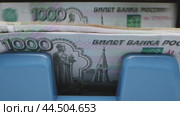 A close-up of a 1000 ruble banknote in a blue money counter. Стоковое видео, видеограф Сергей Толмачёв / Фотобанк Лори