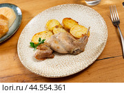 Lunch is served on plate - pieces of young rabbit cooked with segments of potato. Close-up. Стоковое фото, фотограф Яков Филимонов / Фотобанк Лори