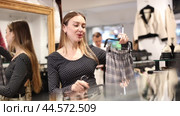 Young woman choosing skirt in clothing store. Стоковое видео, видеограф Яков Филимонов / Фотобанк Лори