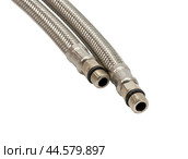 Сантехнический шланг в металлической оплетке для воды на белом фоне. Plumbing hose in a metal braid for water. Стоковое фото, фотограф Татьяна Д / Фотобанк Лори