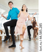Cheerful young couple dancing vigorous lindy hop at group rehearsal. Стоковое фото, фотограф Яков Филимонов / Фотобанк Лори