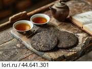 Traditional tea ceremony setup with puerh cakes. Стоковое AI-изображение, AI-художник Иван Рябоконь / Фотобанк Лори
