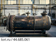 Large rusty industrial autoclave standing on metal platform in factory. Стоковое AI-изображение, AI-художник Иван Рябоконь / Фотобанк Лори