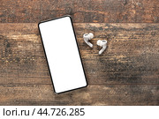 Mockup modern smartphone with blank white screen. earphones and mobile phone with blank screen on copy space white background. Top view mock up , flat lay, copy space. Стоковое фото, фотограф Павел Муравьев / Фотобанк Лори