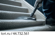 Efficient cleaning of carpeted stairs using a vacuum cleaner in a modern home setting on a sunny afternoon. Стоковое AI-изображение, AI-художник Сергей Толмачёв / Фотобанк Лори
