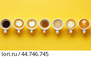 Various hot coffees in ceramic cups lined up on a yellow background. Стоковое AI-изображение, AI-художник Veniamin Kraskov / Фотобанк Лори
