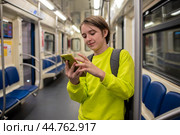 мальчик переписывается используя смартфон в вагоне метро. Стоковое фото, фотограф Яна Проничева / Фотобанк Лори