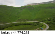 Exploring vibrant green hills and winding roads in a serene landscape. Стоковое видео, видеограф Roman Zavorotny / Фотобанк Лори