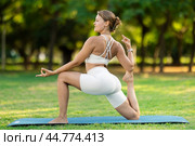 Girl in park on green grass of lawn performs Anjaneyasana. Стоковое фото, фотограф Яков Филимонов / Фотобанк Лори