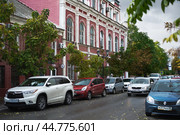Астрахань. Вдоль главной улицы города припаркованные автомобили. По центру - дом, памятник архитектуры, который впоследствии сильно пострадает от пожара. В этом доме с 90-х годов 19 века  жил и работал известный астраханский архитектор, Сергей Иванович Карягин. (2017 год). Редакционное фото, фотограф Павел Просянов / Фотобанк Лори