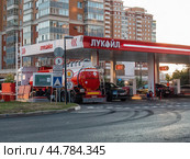 Бензовоз сливает топливо на АЗС Лукойл. Топливозаправщик на автомобильной заправке. Редакционное фото, фотограф Константин Григорьев / Фотобанк Лори