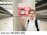 Москва, Россия. 17 сентября 2024. Мальчик стоит на станции мето, указывает на табличку с надписью "Если ты потерялся оставайся здесь. Помни-уходить с чужими никуда нельзя. Тебе могут помочь только полицейский и дежурный по станции" Редакционное фото, фотограф Яна Проничева / Фотобанк Лори