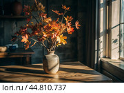 Branches with golden autumn leaves in a ceramic vase on a wooden table by the window. The concept of home comfort. Autumn decor for Halloween. Стоковое AI-изображение, AI-художник Photojuli / Фотобанк Лори