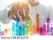 Increased profits. Benchmarking. Businessman analyzes profitability of working companies with digital augmented reality graphics, positive indicators, growing up graph and charts, colorful arrows. Стоковое AI-изображение, AI-художник Марина Демидюк / Фотобанк Лори