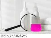 Lice treatment product next to a nit comb and magnifying glass. Стоковое фото, фотограф Сергей Толмачёв / Фотобанк Лори