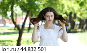 Young brunette girl poses for the camera in a summer park. Стоковое видео, видеограф Андрей Аркуша / Фотобанк Лори
