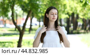 Young brunette girl poses for the camera in a summer park. Стоковое видео, видеограф Андрей Аркуша / Фотобанк Лори