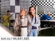 Girl and grandmother in quest room with friends, trying to find solution of conundrum. Стоковое фото, фотограф Яков Филимонов / Фотобанк Лори