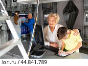 Portrait of grandmother with her grandson at computer, thinking about solving puzzle in quest room. Стоковое фото, фотограф Яков Филимонов / Фотобанк Лори