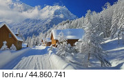 Sun shining on snow covered wooden cabins in mountain village. Стоковое AI-видео, аниматор Юрий Поздников / Фотобанк Лори