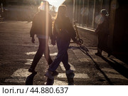 Молодая пара идет по улице к входу в метро держась за руку в солнечный день в городе Москве, Россия. Редакционное фото, фотограф Николай Винокуров / Фотобанк Лори