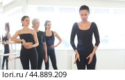 Female teacher leading ballet class, showing graceful dance movements for women of different ages standing at barre, emphasizing discipline in studio. Стоковое видео, видеограф Яков Филимонов / Фотобанк Лори