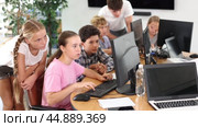 Interested preteen boys and girls working on computer together with teacher in IT cabinet. Стоковое видео, видеограф Яков Филимонов / Фотобанк Лори