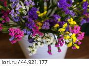 Bouquet of multicolored flowers in a vase (Limonium sinuatum, Statice sinuata) on a green background. Стоковое фото, фотограф Ирина Вершинская / Фотобанк Лори