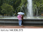 Tourists in rain near Fountain in Alexander Garden in center of St. Petersburg, Russia (2024 год). Редакционное фото, фотограф Валерия Попова / Фотобанк Лори