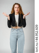 Young Curly Clueless Woman Holding Out Hands. Стоковое фото, фотограф Сергей Толмачёв / Фотобанк Лори