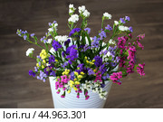 Bouquet of multicolored flowers in a vase (Limonium sinuatum, Statice sinuata) on a green background. Стоковое фото, фотограф Ирина Вершинская / Фотобанк Лори